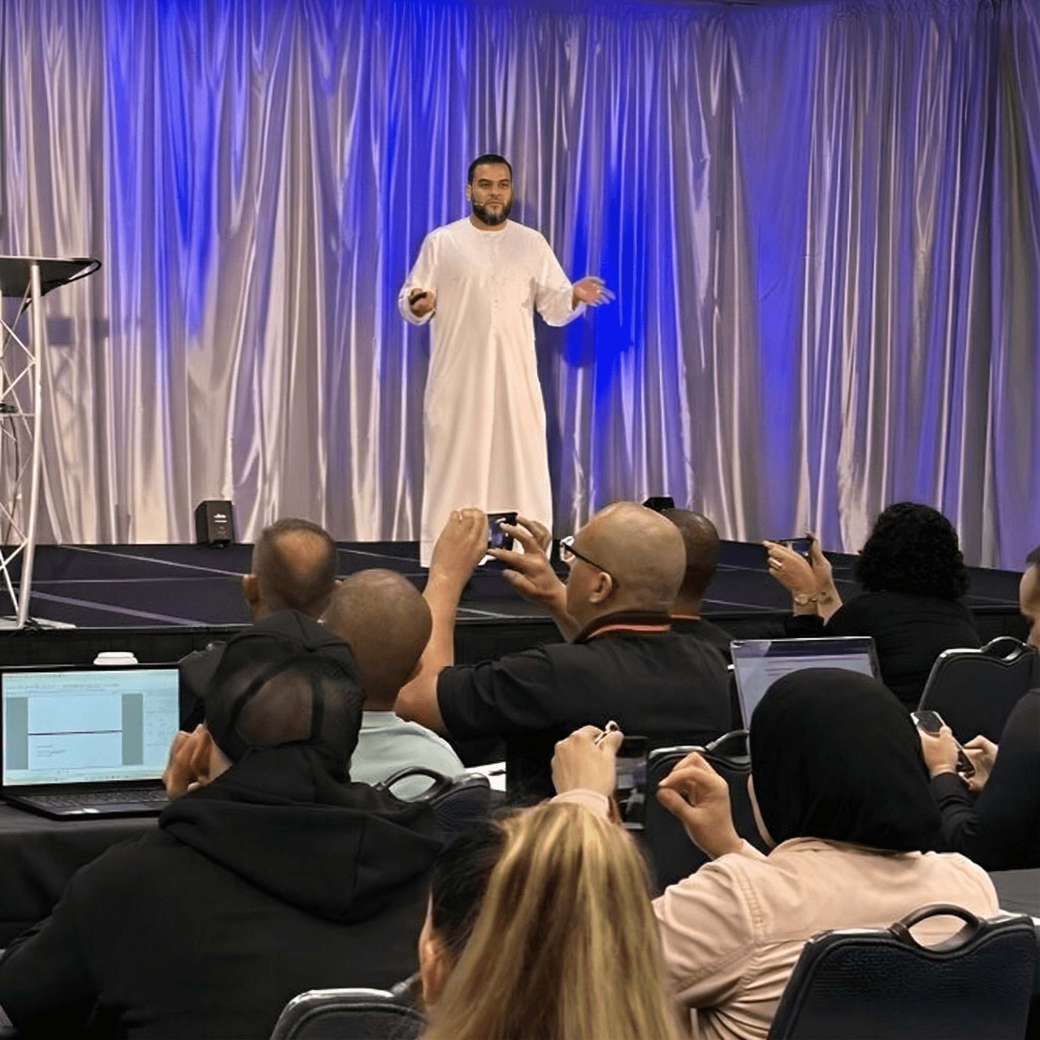 Muhammad Asmal speaking on stage